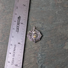 Load image into Gallery viewer, A silver spider with a smooth opal stone set into the abdomen lays flat on a slate tile with a ruler to show size

