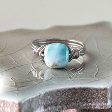 Load image into Gallery viewer, Silver ring with a square shaped light blue larimar stone on a textured surface
