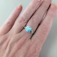 Load image into Gallery viewer, Hand wearing a silver ring with a square shaped larimar stone on a neutral background
