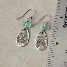 Load image into Gallery viewer, Silver teardrop earrings with green beads on a light gray background with a ruler for scale.
